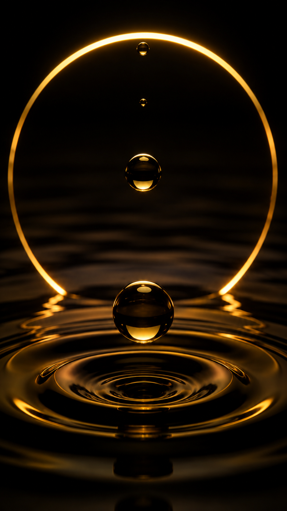 A gold ring, droplet suspended above a rippling gold surface.
